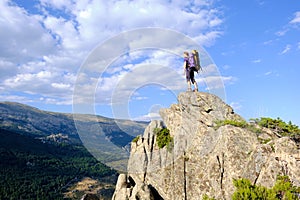 Woman with a backpack standing on top of a mountain