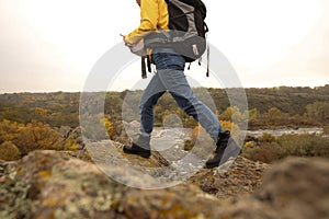 Woman with backpack on steep cliff, closeup