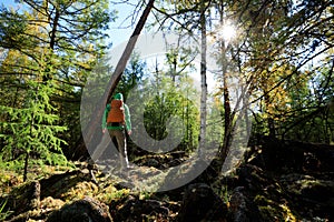 Woman with backpack in the sunrise forest