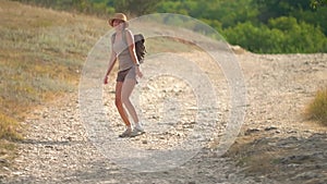 Woman with backpack walking away alone at road in mountains. Travel lifestyle concept adventure outdoor summer vacations