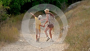 Woman with backpack walking with her son at road in mountains. Travel lifestyle concept adventure outdoor summer