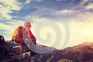 Woman backpacker enjoy the view on mountain peak cliff