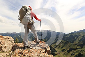 Woman backpacker enjoy the view on mountain peak cliff