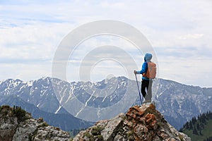 Woman backpacker enjoy the view on mountain peak cliff