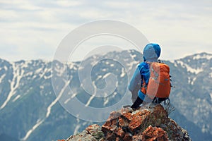 Woman backpacker enjoy the view on mountain peak cliff