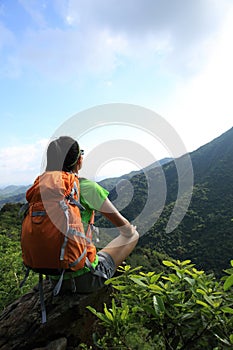 Woman backpacker enjoy the view on mountain peak