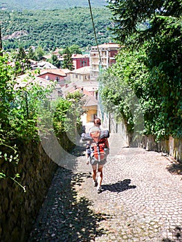 Woman backpacker hikes into a mediterranean Europen village