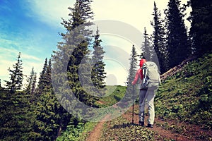 woman backpacker hiking on beautiful mountain peak trail