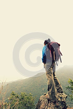 Woman backpacker hiking at mountain peak