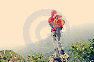 Woman backpacker hiking at mountain peak