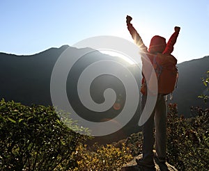 Woman backpacker hiking on mountain peak