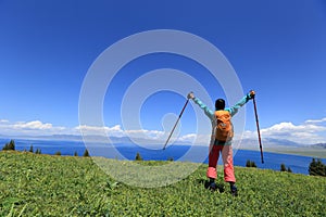 Woman backpacker hiking on mountain peak