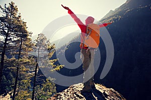 Woman backpacker hiking on mountain peak