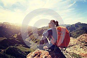 woman backpacker hiking on mountain peak cliff