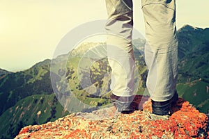 Woman backpacker hiking on mountain peak cliff