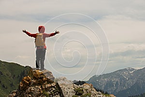 woman backpacker hiking on mountain peak cliff