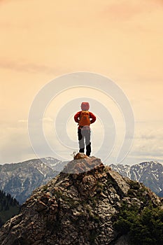 woman backpacker hiking on mountain peak cliff