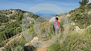 Woman backpacker  hiking within mountain trek on Mallorka islan. Sunny spring  day with comfortable temperature.