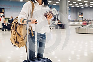 Woman backpacker holding passport and map with suitcase standing