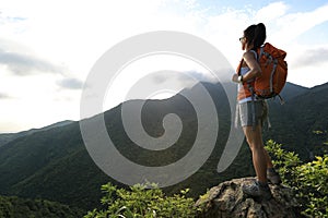 Woman backpacker on mountain peak