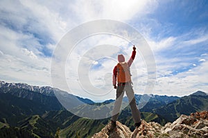 Woman backpacker on mountain peak