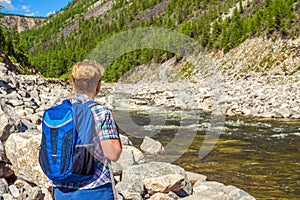 Woman backpacker at the mountain river