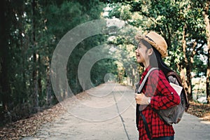 Woman backpacker in the road and forest background