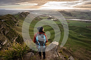 Woman backpacker standing at the top of Te Mata Peak in Hawke`s Bay, New Zealand