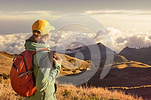 Woman backpacker traveling with backpack standing on top of the