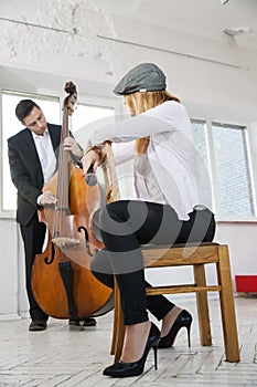 Woman backwards on chair listen contrabass play