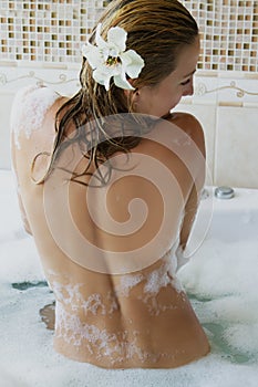 Woman backwards with foam in jacuzzi