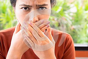 Woman with bad breath covering mouth, halitosis concept