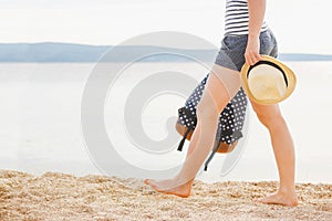 Woman with bag and sun hat going on the beach