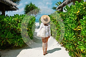 Woman with bag and sun hat going to beach