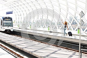 Woman with bags running on platform in station to catch train