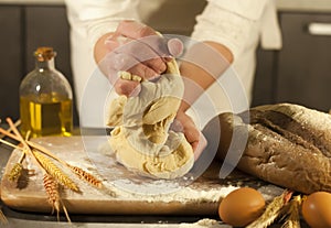 Woman baker hands, kneads dough and making housework making bread, butter, tomato flour