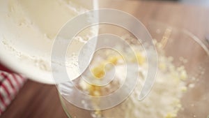 Woman baker sifting flour for dough through bolter.