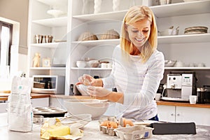 Woman baking at home following recipe on a tablet