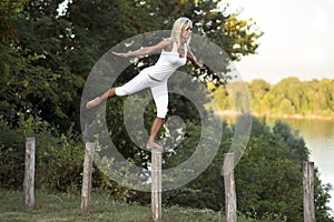 Woman balancing on fence post