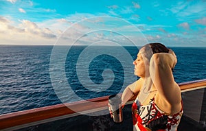 Woman on the balcony of a cruise ship at sunrise