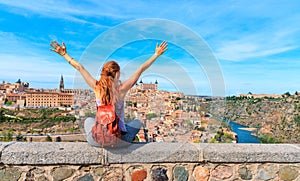 Woman on balcony in front of the skyline from Toledo