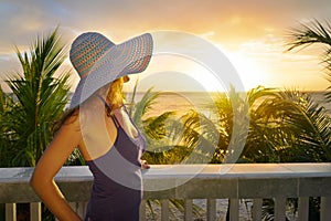 Woman on a balcony looking at the beautiful Caribbean sunset
