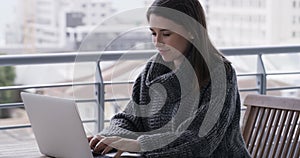 Woman, balcony and typing on laptop at home, technology and internet connection for website. Female person, rooftop and