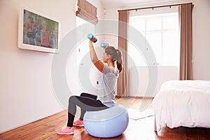 Woman On Ball Working Out To Fitness DVD On TV In Bedroom