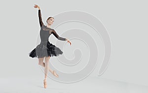 Woman ballet dancer over gray background.