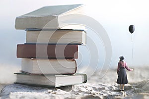 Woman with balloon looks amazed at a mountain of giant books