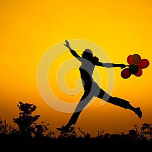 Woman with balloons jumping on the nature