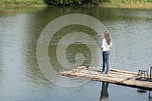 Woman on a bamboo raft in river