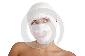 Woman with bandaged head with drawn smile