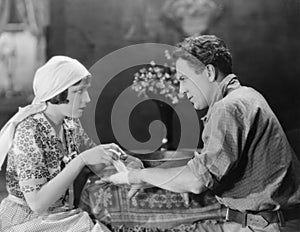 Woman bandaging mans hand